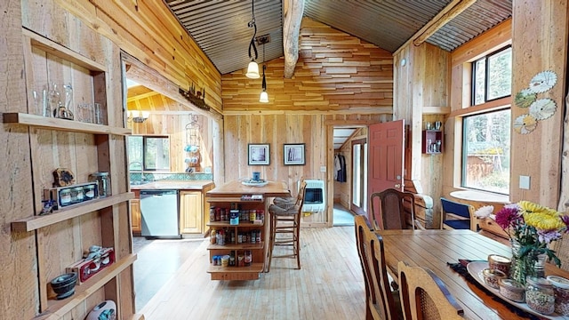 dining area featuring plenty of natural light, light wood-type flooring, heating unit, and wooden walls