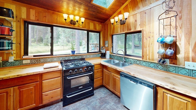 kitchen with butcher block countertops, sink, black gas range, wooden walls, and stainless steel dishwasher