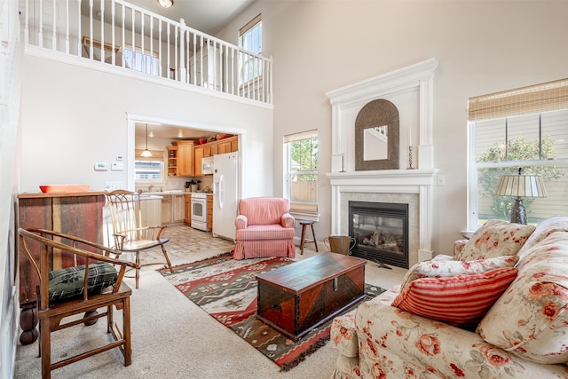 living room with a high ceiling and a tile fireplace