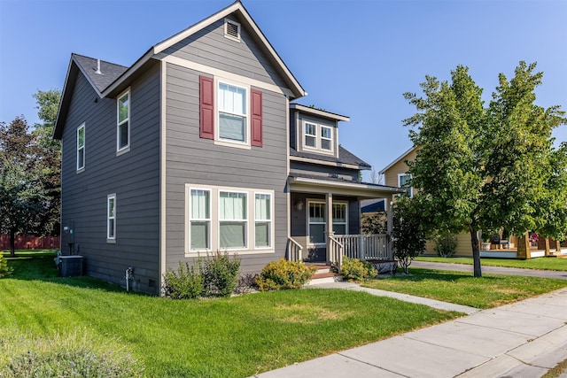 view of front of home featuring a porch, cooling unit, and a front yard