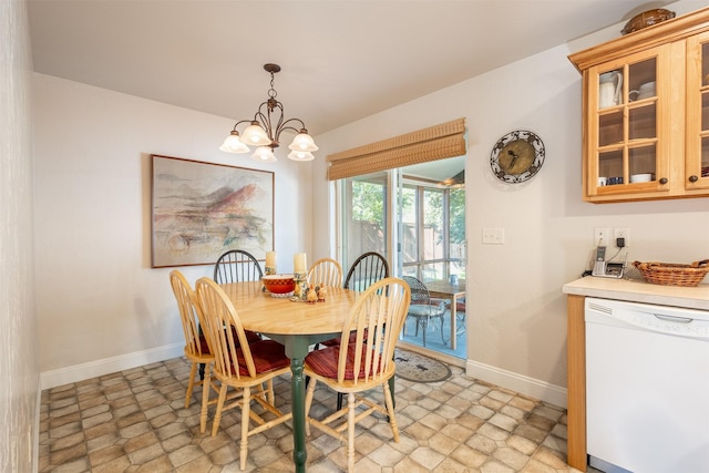 dining room with baseboards, stone finish flooring, and an inviting chandelier