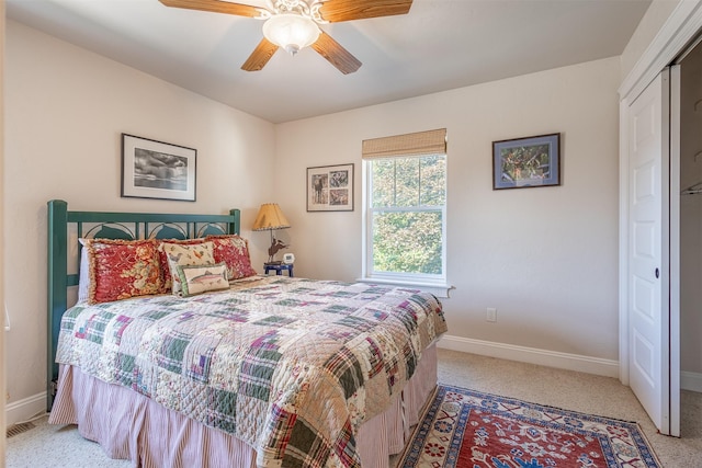 bedroom with a ceiling fan, light colored carpet, and baseboards