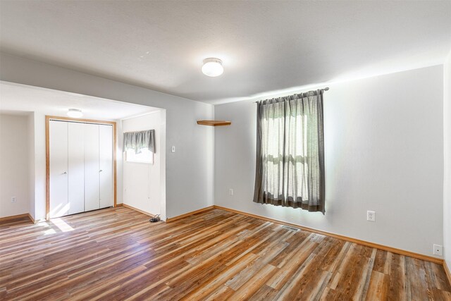 unfurnished room with hardwood / wood-style floors