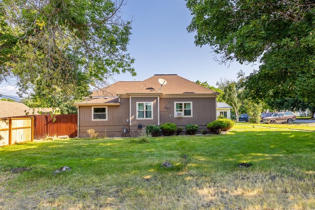 rear view of house featuring a lawn