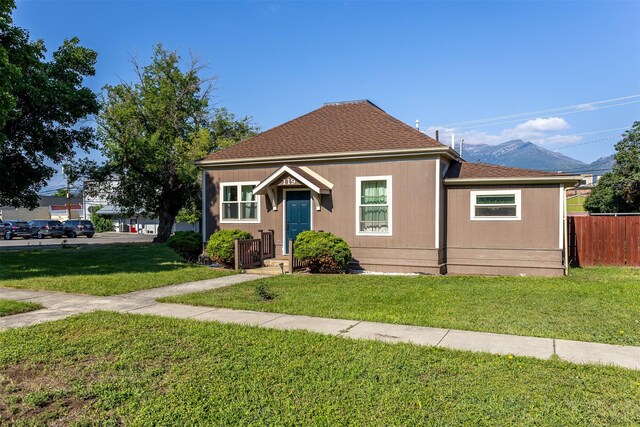 bungalow-style house with a mountain view and a front lawn