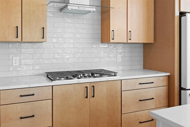 kitchen with appliances with stainless steel finishes, extractor fan, tasteful backsplash, and light brown cabinetry