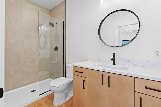 bathroom with walk in shower, wood-type flooring, vanity, and toilet