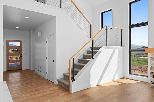 interior space featuring a towering ceiling and light hardwood / wood-style flooring