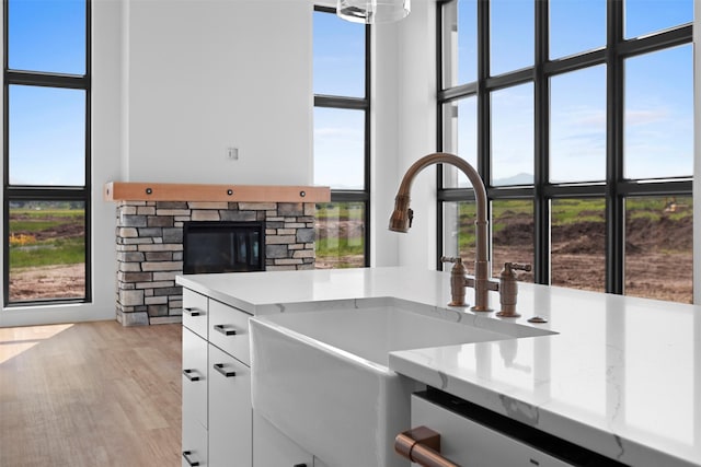 kitchen with light stone countertops, light hardwood / wood-style flooring, and a healthy amount of sunlight