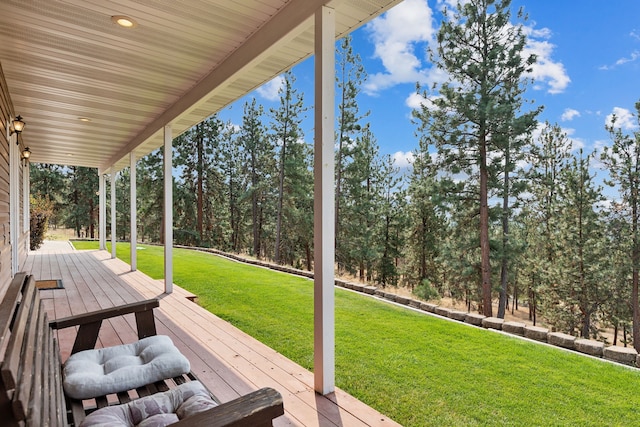 wooden terrace featuring a lawn