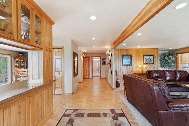 living room with light wood-type flooring and wood walls