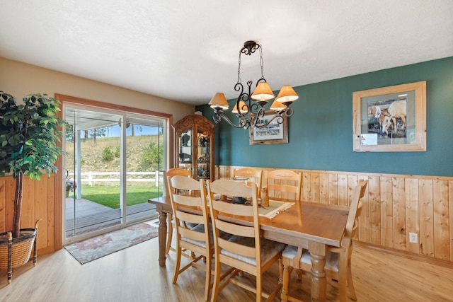 dining space featuring light wood-type flooring and a chandelier