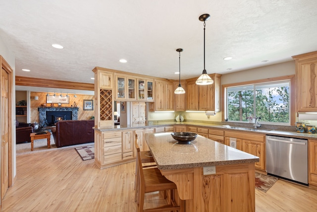 kitchen featuring a breakfast bar area, pendant lighting, dishwasher, light hardwood / wood-style floors, and a center island