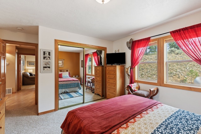 bedroom with light carpet and a closet