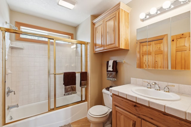 full bathroom featuring enclosed tub / shower combo, toilet, vanity, and wood-type flooring