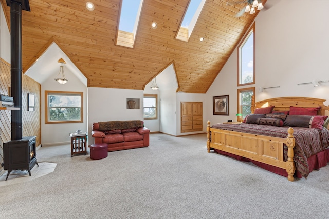 bedroom with wooden ceiling, light carpet, high vaulted ceiling, a skylight, and a wood stove