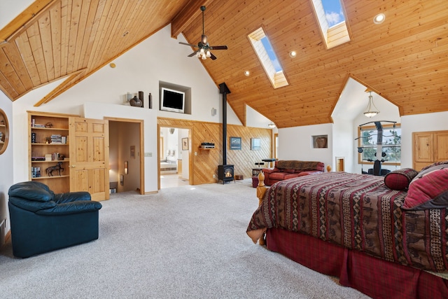 bedroom with a skylight, carpet, high vaulted ceiling, beam ceiling, and a wood stove