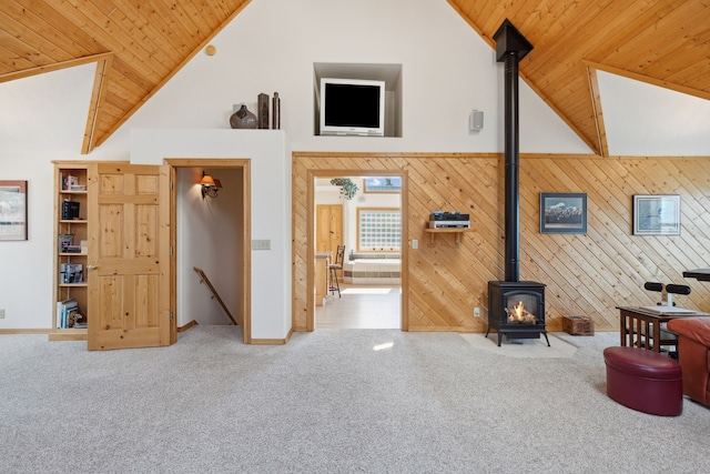 living room with wooden ceiling, a wood stove, high vaulted ceiling, and carpet floors