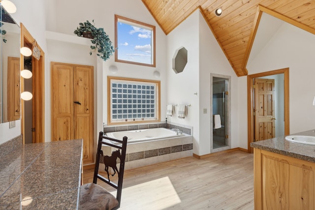 bathroom featuring vanity, high vaulted ceiling, tiled bath, and wood ceiling