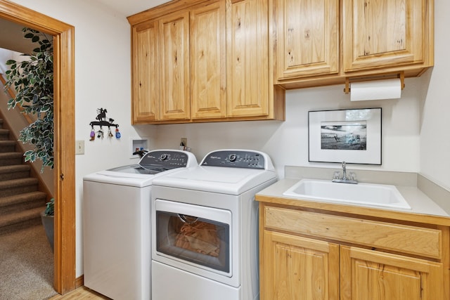 washroom featuring cabinets, washing machine and dryer, sink, and light colored carpet