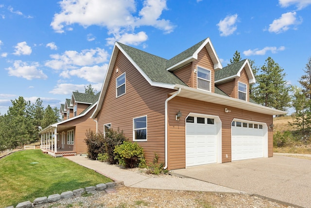 view of side of property with a yard, a garage, and a porch