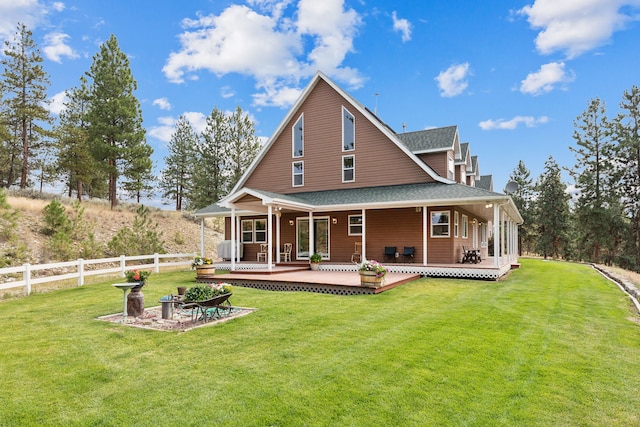 back of property with covered porch and a yard