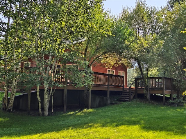 rear view of house featuring a yard and a wooden deck