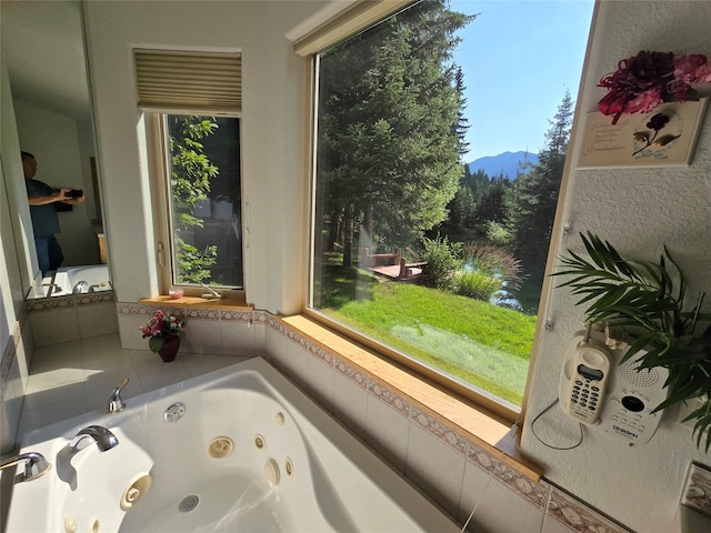 bathroom with tiled tub and a mountain view