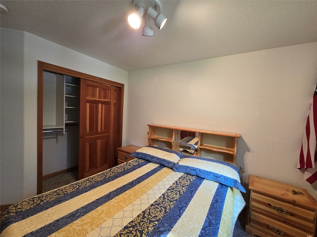 bedroom featuring a textured ceiling, ceiling fan, and a closet