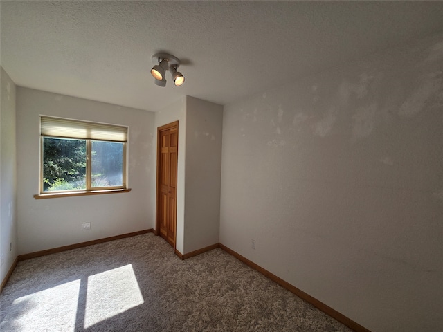 unfurnished bedroom with carpet flooring, a textured ceiling, and a closet