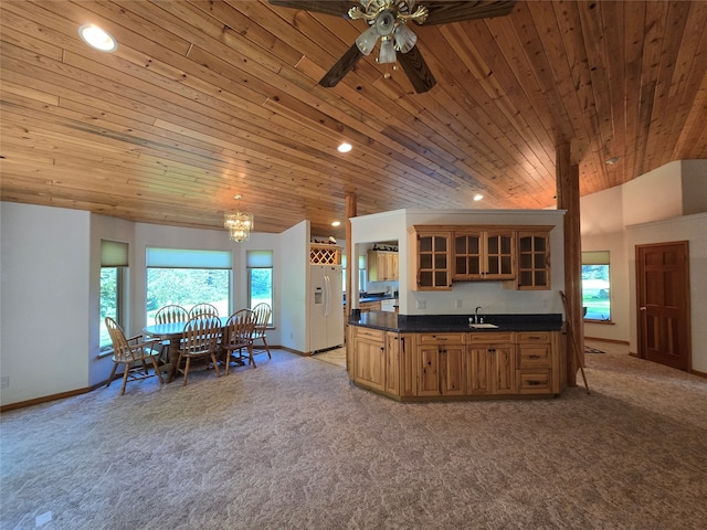 kitchen featuring white refrigerator with ice dispenser, a healthy amount of sunlight, ceiling fan, and wooden ceiling