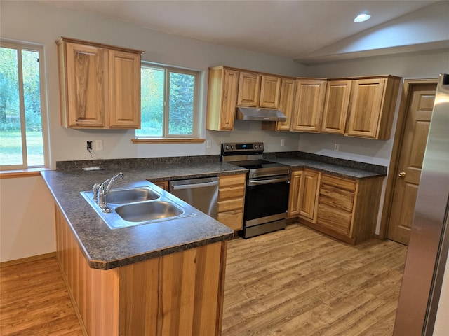 kitchen with light hardwood / wood-style flooring, appliances with stainless steel finishes, kitchen peninsula, sink, and lofted ceiling