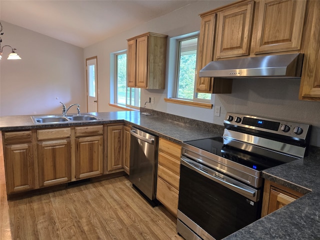 kitchen featuring stainless steel appliances, sink, and light hardwood / wood-style floors