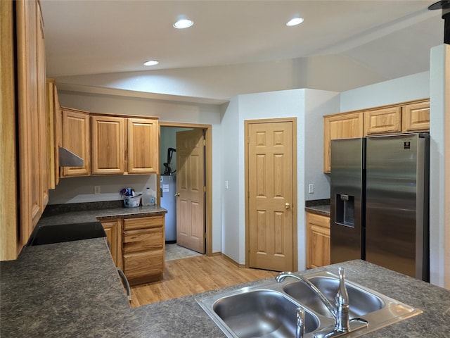 kitchen featuring vaulted ceiling, sink, stainless steel fridge, and light hardwood / wood-style floors