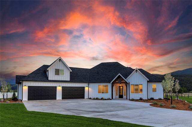 modern farmhouse featuring concrete driveway, a garage, board and batten siding, and a front lawn