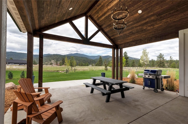 view of community featuring a rural view, a patio, a lawn, and a mountain view