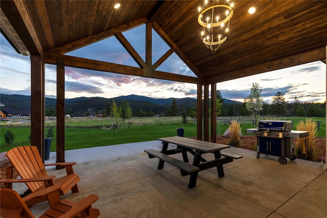 view of community with a patio area, a mountain view, and a lawn