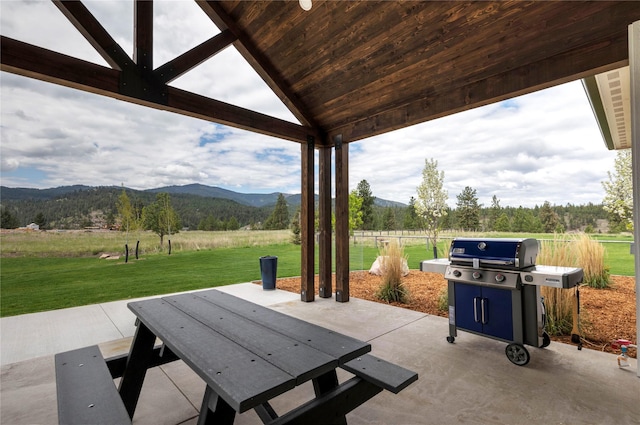 view of patio with area for grilling, a rural view, and a mountain view