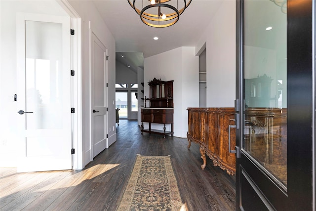 hall with an inviting chandelier, recessed lighting, and dark wood-style flooring