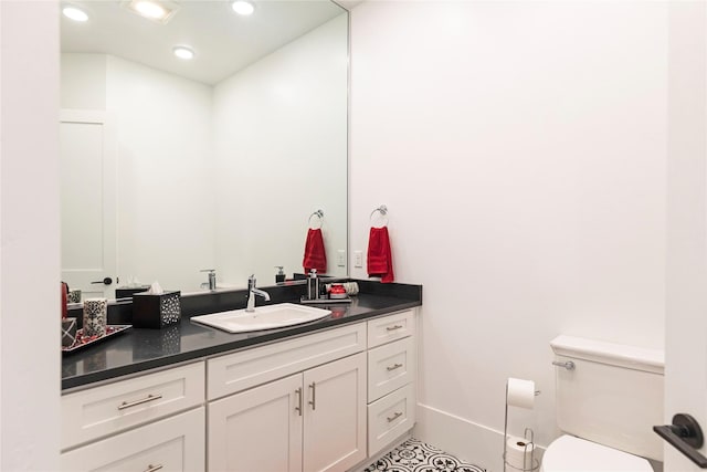 bathroom with vanity, toilet, and recessed lighting