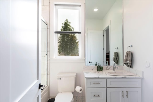 full bathroom with vanity, toilet, and enclosed tub / shower combo