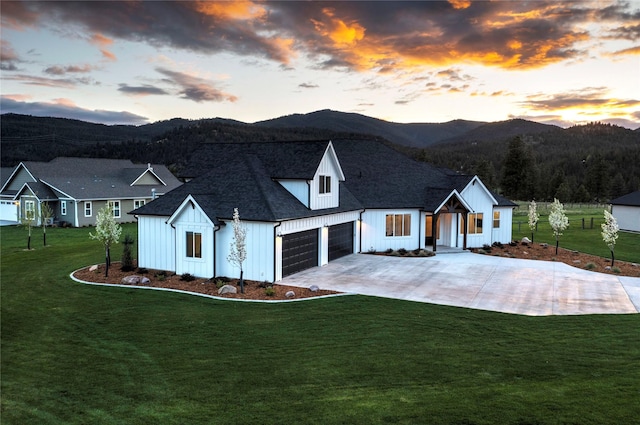 modern farmhouse style home with a mountain view, board and batten siding, and a front lawn