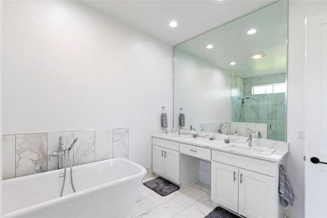 bathroom featuring a freestanding bath, double vanity, marble finish floor, and a sink