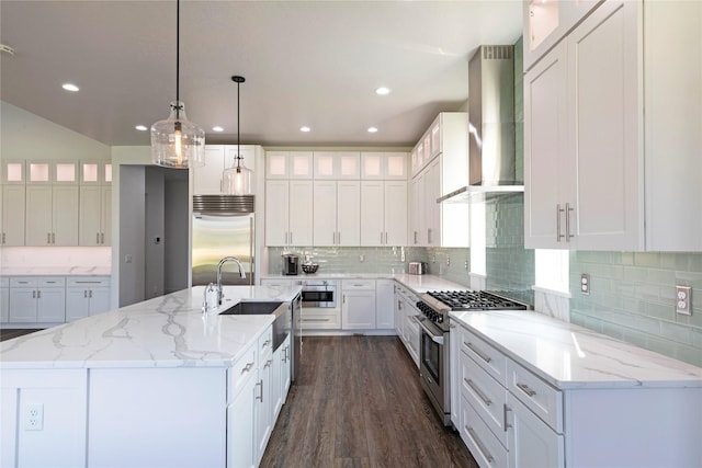 kitchen with a center island with sink, high quality appliances, dark wood-style flooring, a sink, and wall chimney exhaust hood