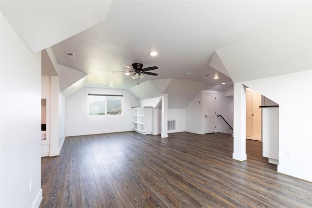 additional living space featuring visible vents, a ceiling fan, a textured ceiling, lofted ceiling, and dark wood-style flooring