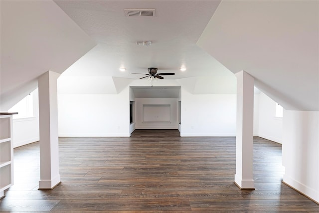 additional living space featuring visible vents, baseboards, dark wood-type flooring, and ceiling fan