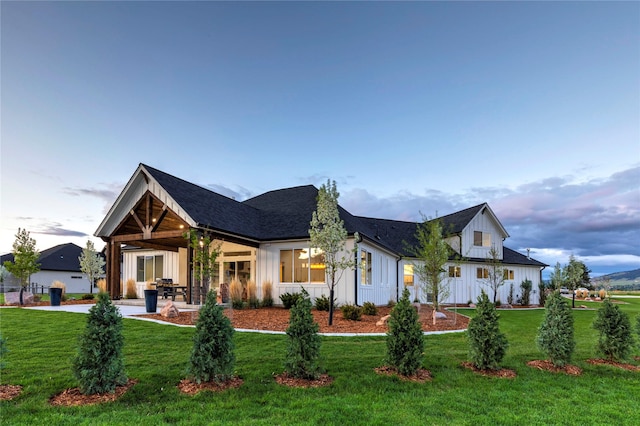 view of front of property featuring a patio area, board and batten siding, and a front lawn