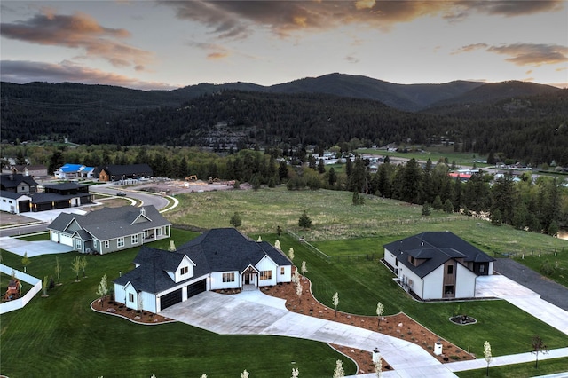 drone / aerial view with a wooded view and a mountain view