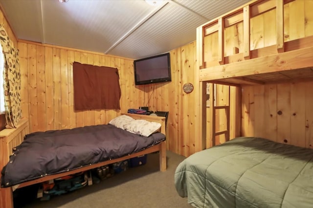 bedroom with carpet floors and wooden walls