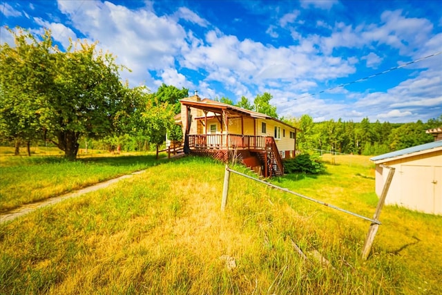 exterior space with a wooden deck and a lawn